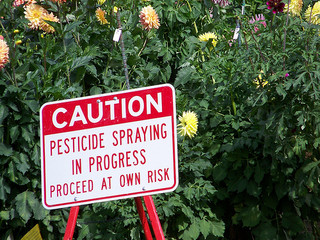 Sign that says caution pesticide spraying in progress